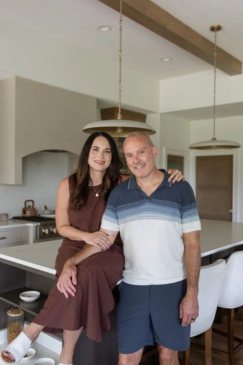 Kalen and Kurt Ludwig at the quartz kitchen island under brass pendant lights