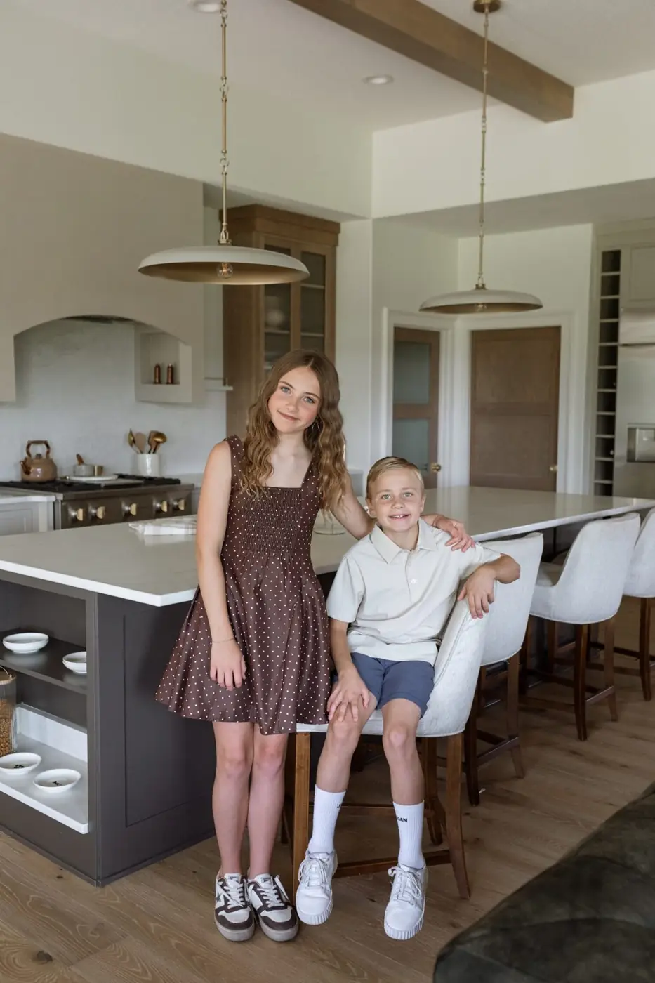 Jules and Wells Ludwig at the white quartz kitchen island with upholstered stools