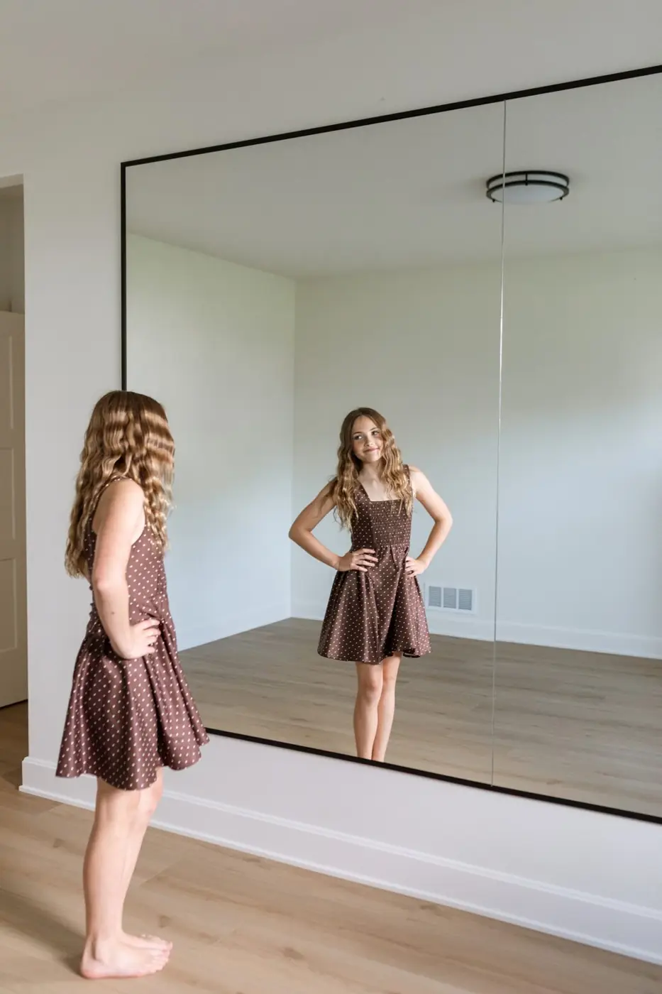 Jules Ludwig standing in front of the full mirrored wall in the home dance studio