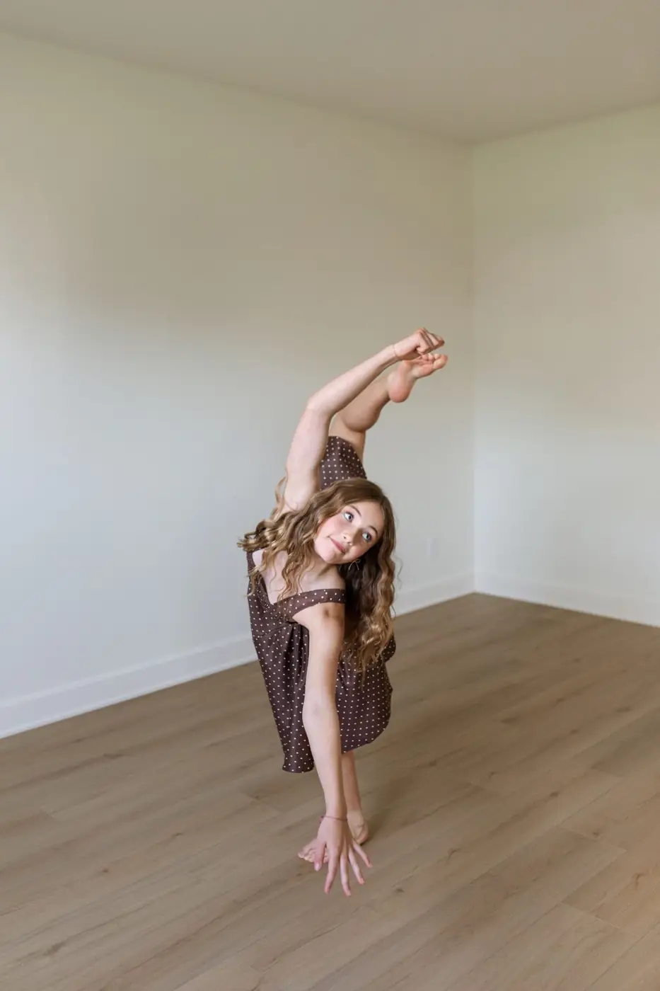Jules Ludwig holding a standing leg extension in the home dance studio