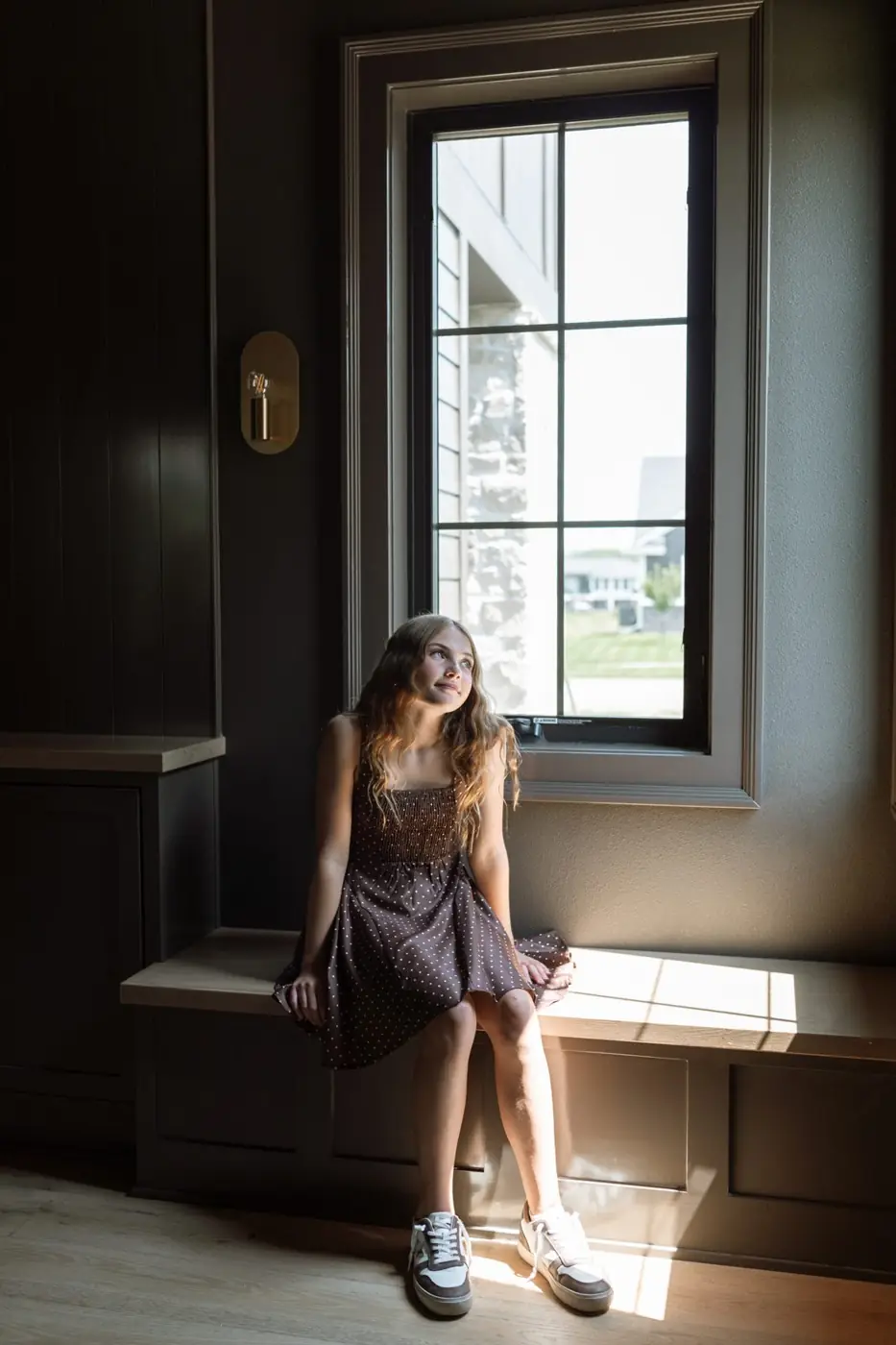 Jules Ludwig in the window seat of Kurt's color-drenched office in dark urban bronze