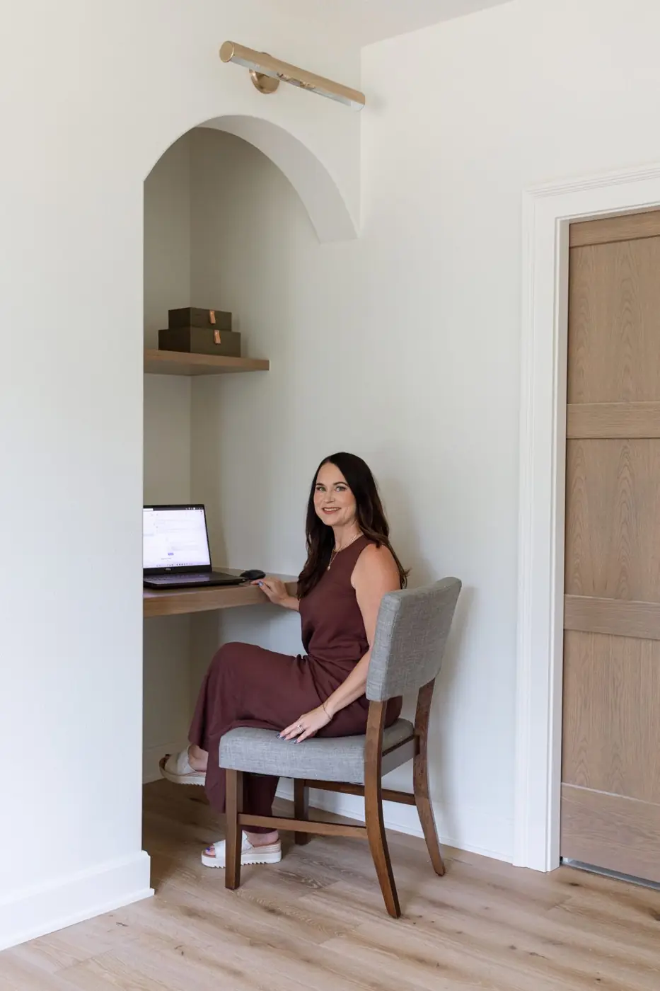 Kalen Ludwig working at a built-in desk niche under an arched alcove